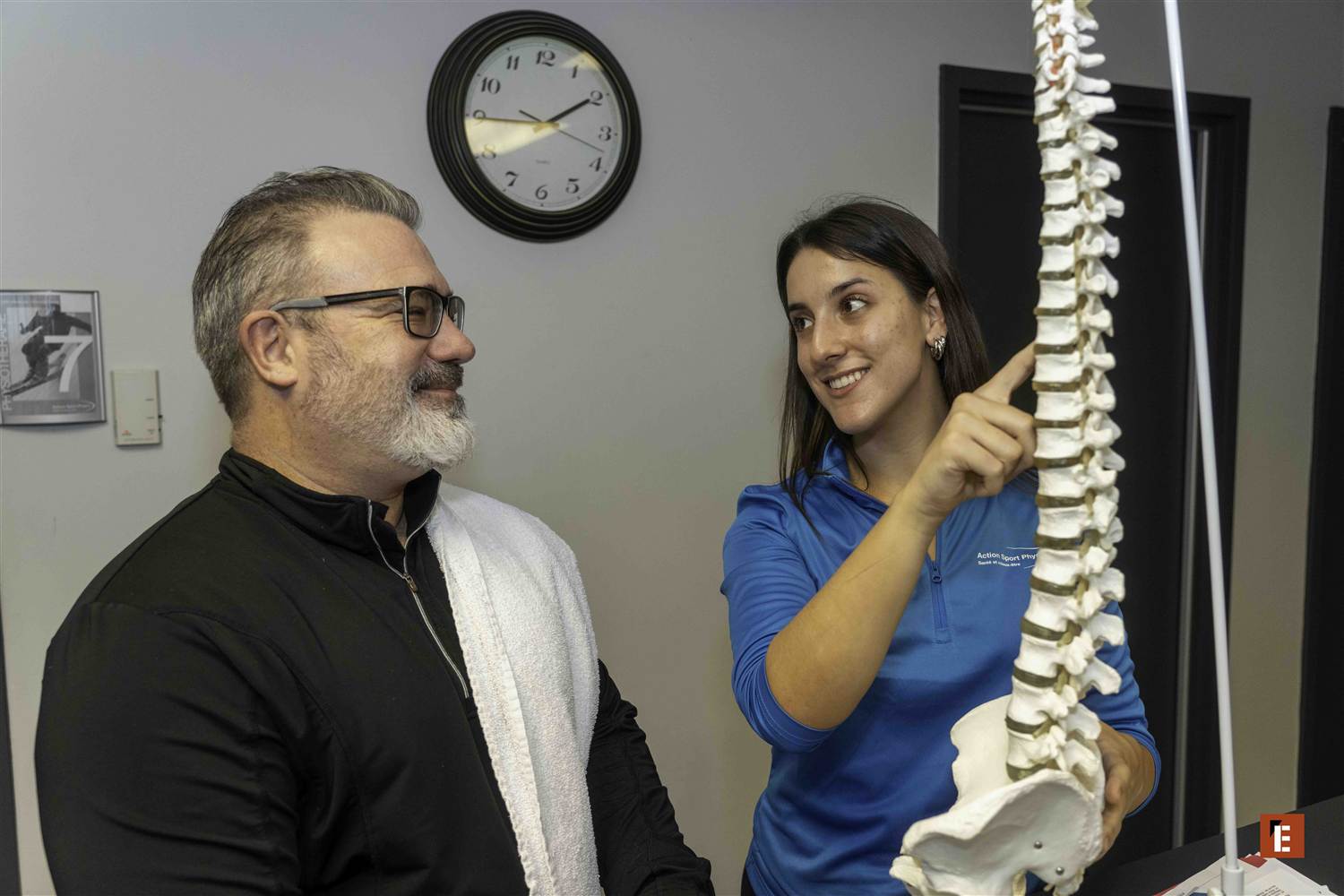 A senior patient and a young clinician laughing together