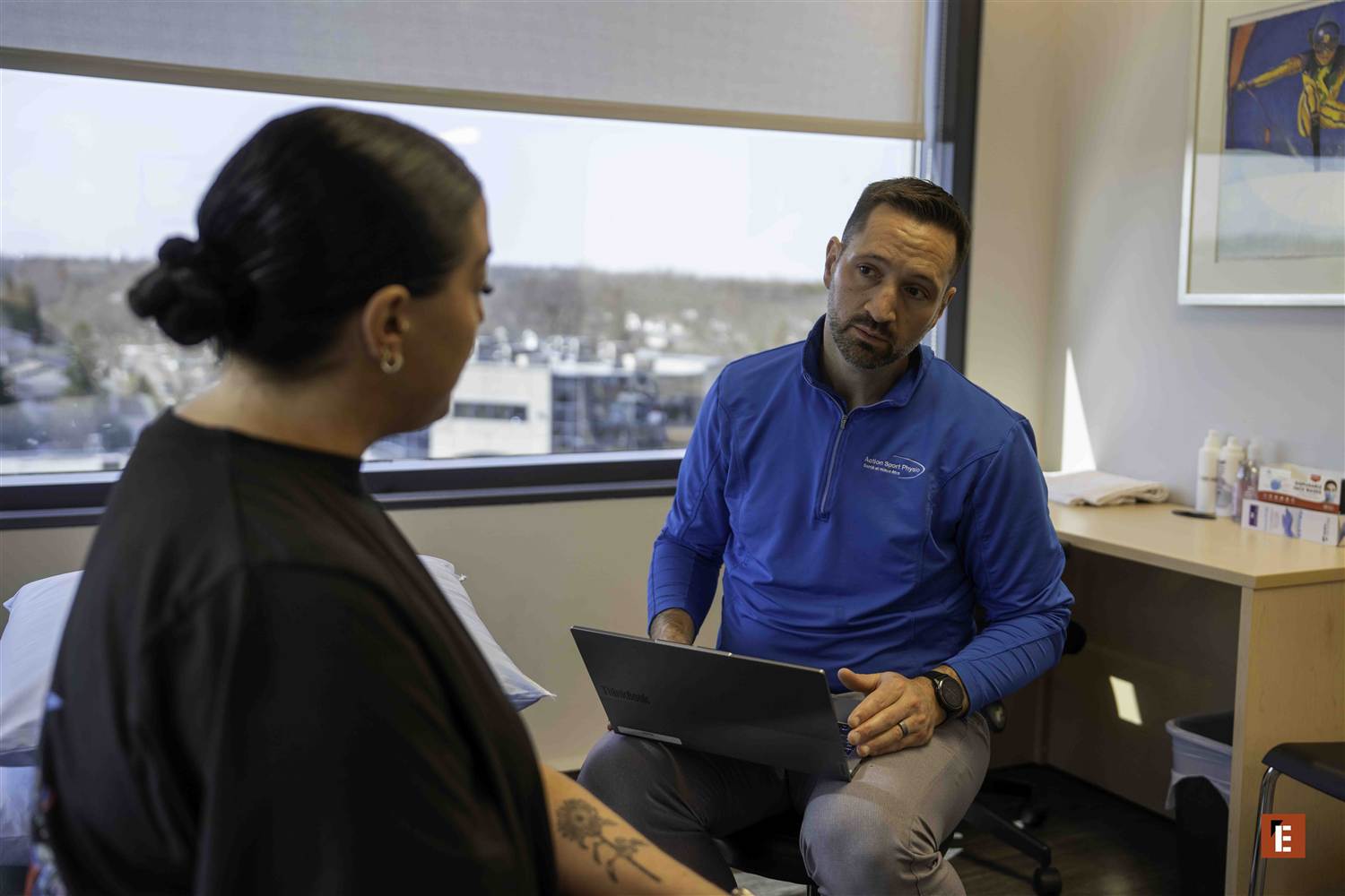 An owner and a clinician talking at a desk